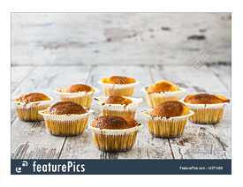 Muffins In Paper Cupcake Holders On Wooden White Table