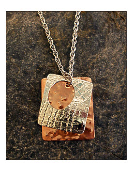 Pendant Has A Sheet Of Hammered Copper Hanging Loosely Behind A Sheet