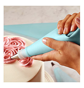 Piping Bag Being Used To Add Design To Cake
